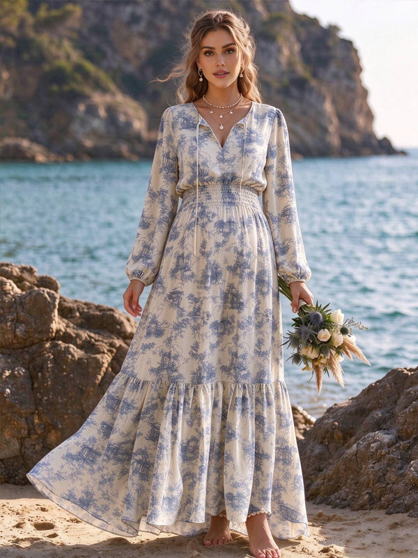 Blue printed maternity maxi dress with lantern sleeves and a high-waisted flowing fit, perfect for a beach photoshoot