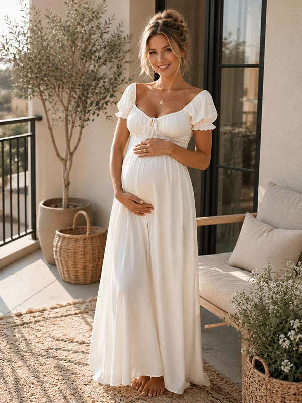 White maternity maxi dress with ruffle ruched lace-up design and flowy silhouette, designed for summer beach photoshoot and baby shower.