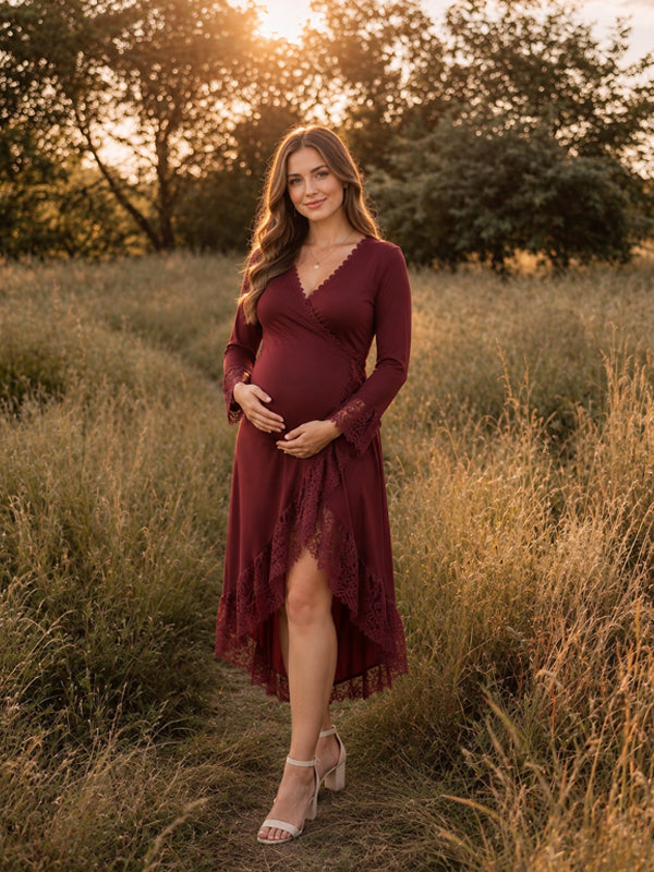 Burgundy V-neck maternity maxi dress with lace panels and an asymmetrical hem, featuring a flowing silhouette for outdoor photoshoots