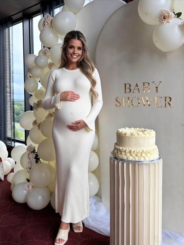 White maternity dress with flared sleeves and a lace-up backless design, featuring an elegant flowing fit for baby showers