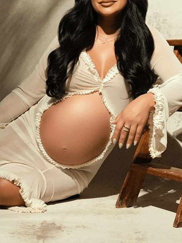 Ivory maternity maxi dress with ruffle cut out design.